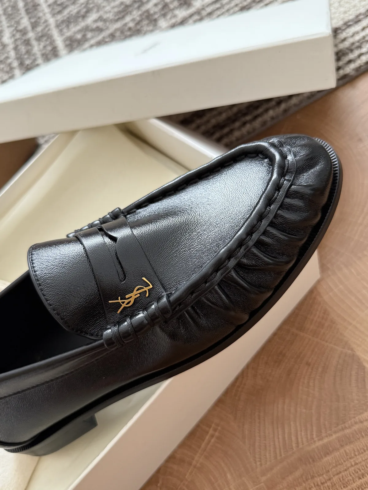Closer side view of a black loafer showing the toe shape and stitched upper